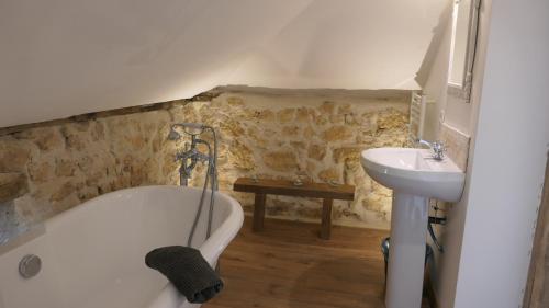 a bathroom with a bath tub and a sink at Le Moulin du Clapier La Banette in Sorges