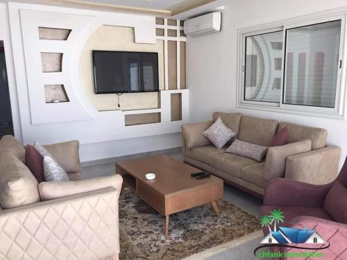 a living room with two couches and a tv at Villa Bacha in Houmt Souk