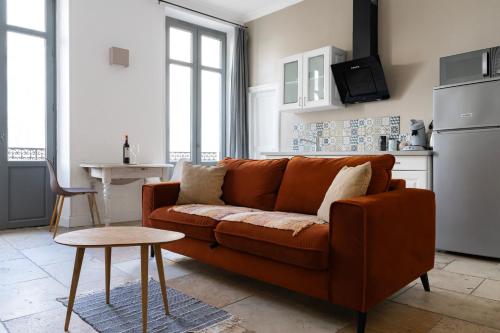 sala de estar con sofá marrón y mesa en Carcassonne Bastide en Carcassonne
