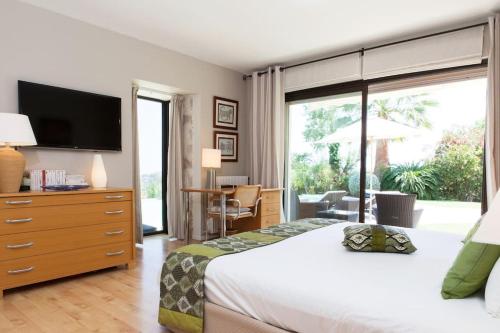 - une chambre avec un lit, une télévision et une porte coulissante en verre dans l'établissement PRESTIGE PROPERTY WITH PANORAMIC SEA VIEW, à Vallauris