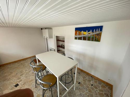 un tavolo bianco e sedie in una stanza di Maison en pleine nature a Saint-Maurice-en-Gourgois
