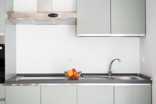 a kitchen with white cabinets and a bowl of fruit at @uRhOME - Luxury Accommodation in Rome