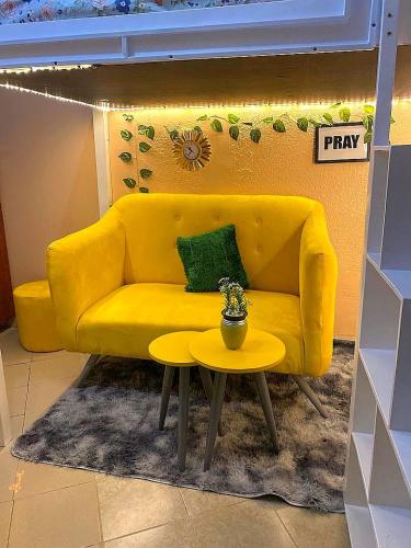 un sofá amarillo y una mesa en una habitación en Petite paradise, en Kampala