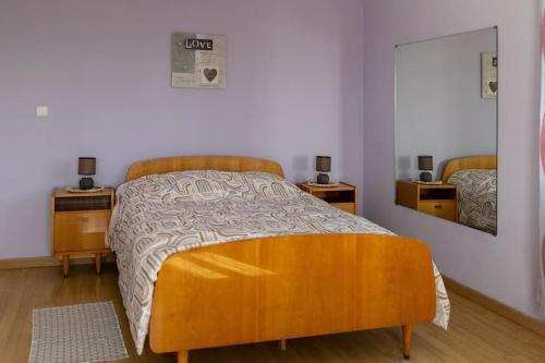 - une chambre avec un lit, 2 tables de chevet et un miroir dans l'établissement L'hébergement du Faubourg Landrecies, à Landrecies