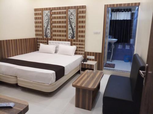 a bedroom with a bed and a table and a window at HOTEL R K RESIDENCY MUZAFFARPUR in Muzaffarpur
