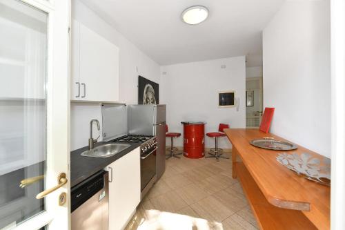 a kitchen with a counter top and a wooden table at Relais Villa Isabel in Pietrasanta