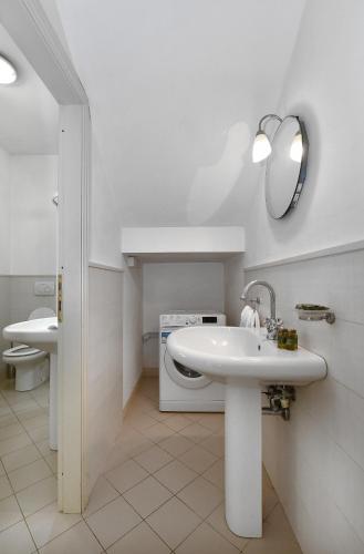 a bathroom with a sink and a washing machine at Relais Villa Isabel in Pietrasanta