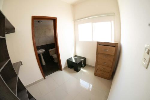 uma casa de banho com um WC, um lavatório e um espelho. em Room in Guest room - 22 Suite for two people em Torreón