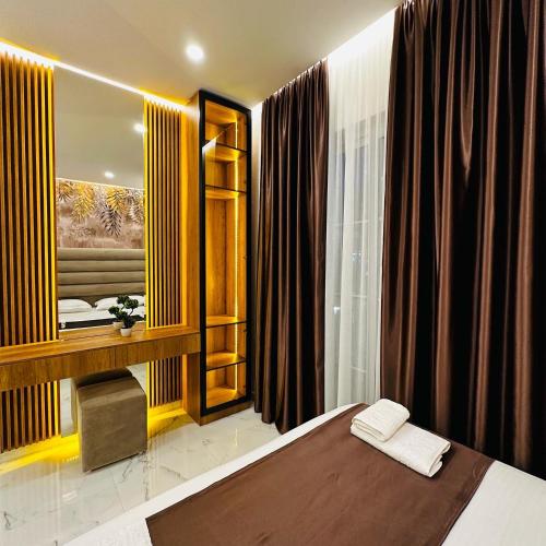 a bedroom with a large bed and a mirror at Apartments Oda Hotel in Velipojë