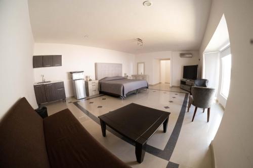 uma grande sala de estar com uma cama e uma mesa em Room in Guest room - 22 Suite for two people em Torreón