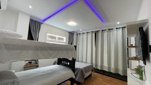 a bedroom with two beds and a purple ceiling at cabaña vereda linda in Juan de Acosta