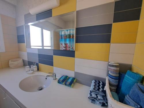 un bagno con lavandino e specchio di Sandy Coast Beach Villa a Larnaka