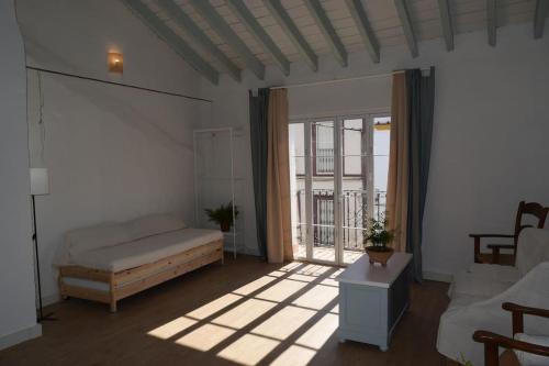 een woonkamer met een bed en een raam bij Casa de la Abuela Dolores in Villaverde del Río