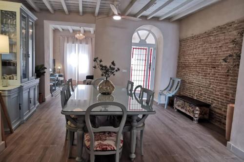 uma sala de jantar com uma mesa e uma parede de tijolos em Casa de la Abuela Dolores em Villaverde del Río