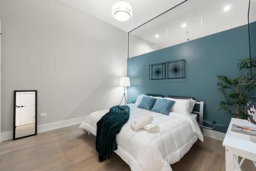 a bedroom with a large bed with a blue wall at Chic River North Condo 2BR 2BA with Private Balcony in Chicago