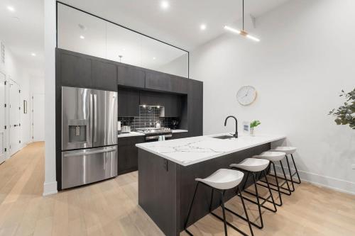 a kitchen with a large island with bar stools at Chic River North Condo 2BR 2BA with Private Balcony in Chicago