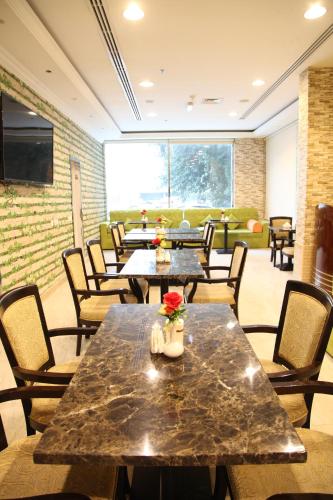 a restaurant with tables and chairs and a couch at Dream Palace Hotel in Ajman 