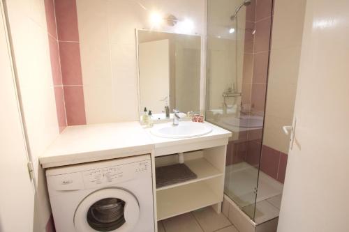 une salle de bain avec une machine à laver et un lavabo dans l'établissement Hossegor-Plage-Surf-Famille-Parking, à Soorts-Hossegor