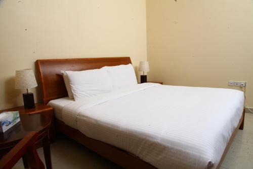 a bedroom with a large bed with white sheets and pillows at Dream Palace Hotel in Ajman 