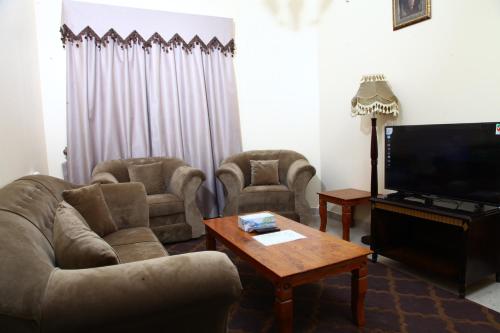 a living room with two couches and a television at Dream Palace Hotel in Ajman 