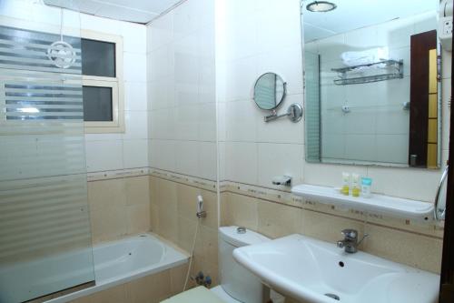 a bathroom with a sink and a toilet and a mirror at Dream Palace Hotel in Ajman 