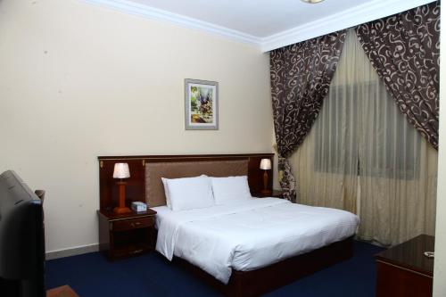 a hotel room with a bed and a window at Dream Palace Hotel in Ajman 
