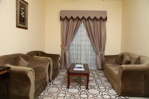 a living room with two couches and a coffee table at Dream Palace Hotel in Ajman 