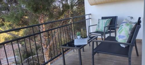 Duas cadeiras e uma mesa numa varanda em Apartamento en la montaña, Serra em Serra