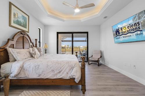 a bedroom with a bed and a large window at Gulf Access, Heated Saltwater Pool, Kayaks - Villa Sunset Lagoon in Matlacha