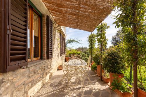 a patio with a table and chairs on a house at Fabio Apartments San Gimignano in San Gimignano