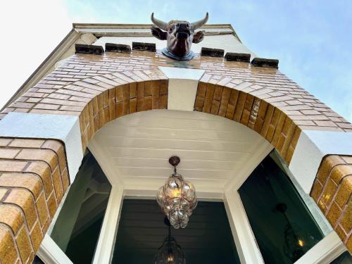 a cow head on a building with a chandelier at B&B Schipperspad in Tolkamer