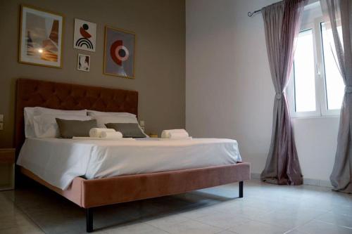 duże łóżko w sypialni z oknem w obiekcie Cathy's Place w mieście Paradeísion