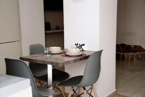 stół z 4 krzesłami i stół z miskami w obiekcie Cathy's Place w mieście Paradeísion