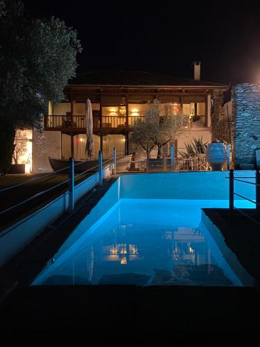 a swimming pool in front of a house at night at Villa Domatia in Kavala