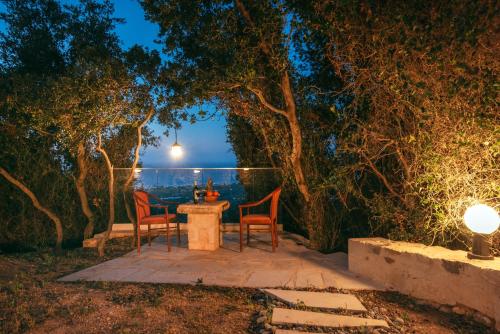 a table and chairs sitting under a tree at night at Maroulas Natura Palace in Giannoudi