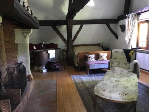 uma sala de estar com um sofá e uma cama em The Manor of Vattetot, historical landmark XII-XVI century em Vattetot-sur-Mer