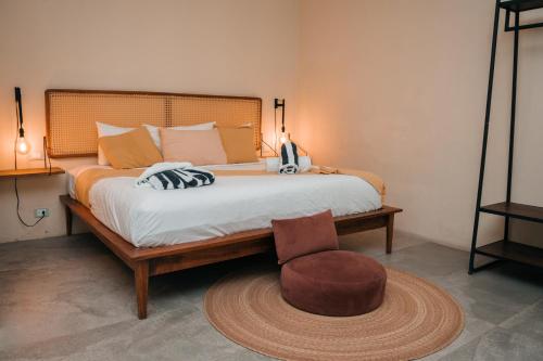 a bedroom with a large bed with a chair at Kinah Retreat - Exclusive Boho Tropical Escape in Tulum