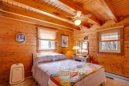 1 dormitorio con 1 cama en una cabaña de madera en Peaceful Luray Cabin with Hot Tub, Deck and Fire Pit!, en Luray