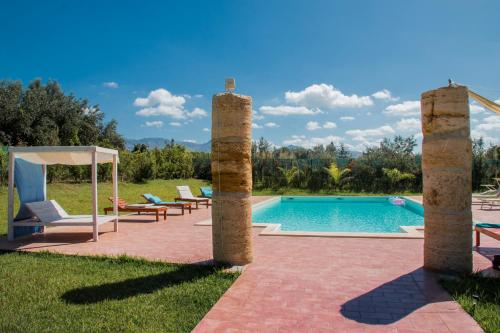 um quintal com piscina e dois pilares de pedra em Villa con piscina Casale di Giò nel Golfo di Castellammare em Partinico