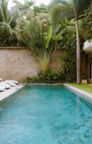 a swimming pool with blue water and palm trees at VillaMag in Jericoacoara