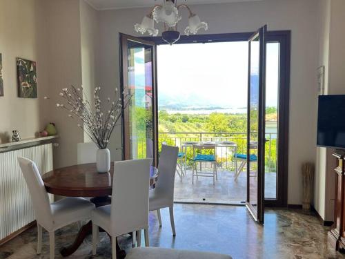 ein Esszimmer mit einem Tisch und Stühlen sowie einem Balkon in der Unterkunft Casa Emy, tranquilla, ottima per Rilassarsi in Montinelle