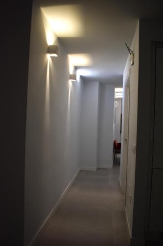 a hallway with a white wall with lights on it at Precioso piso en el centro de Almeria in Almería