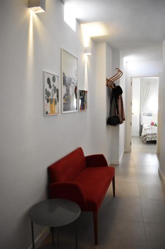 a living room with a red chair and a table at Precioso piso en el centro de Almeria in Almería