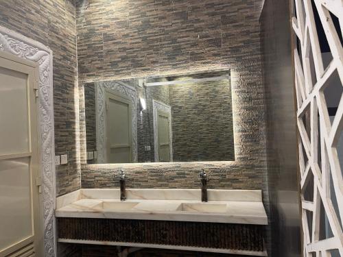 a bathroom with two sinks and a large mirror at منتجع واستراحة اليخت in Khalij Salman