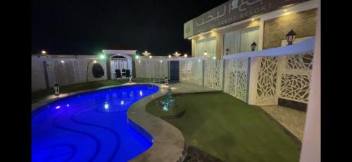 a swimming pool in the middle of a yard at night at منتجع واستراحة اليخت in Khalij Salman
