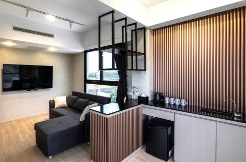 a living room with a couch and a kitchen with a television at Anchorage Lodge in Jian