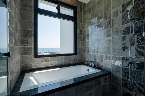 a bathroom with a tub and a window at Anchorage Lodge in Jian