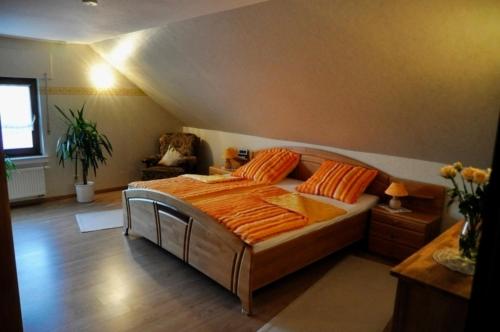 1 dormitorio con 1 cama grande con almohadas de color naranja en Ferienhaus, en Weiler