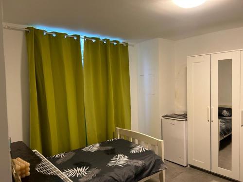 a bedroom with a green curtain and a bed at Chambre 2 lits simples in Brussels
