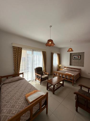ein Hotelzimmer mit 2 Betten und einem Stuhl in der Unterkunft Dimma Seaside Houses in Paphos City
